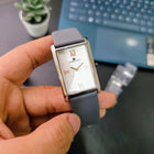 Close-up of Franklord Ash Luxe rectangular watch featuring silver dial and gunmetal case held in hand