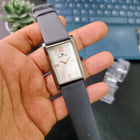 Hand-holding shot of Franklord Ash Luxe dress watch highlighting silver dial and leather strap
