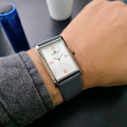  Franklord Ash Luxe rectangular watch on wrist with silver dial, rose gold Roman numerals, and grey strap