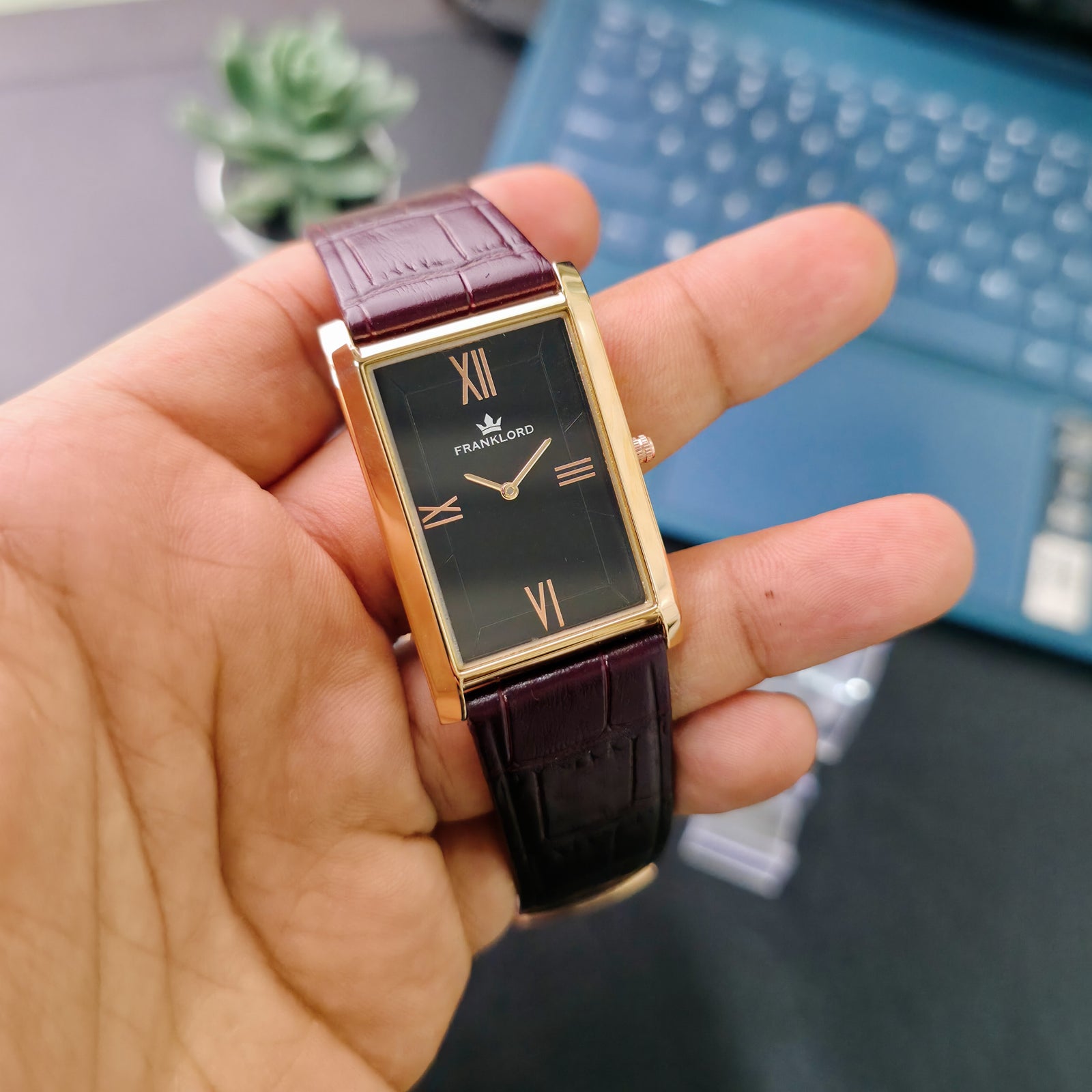 Premium black dial Franklord Black Royale shown in-hand with rose gold rectangular casing and crocodile leather strap