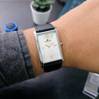 Straight-on wrist shot of Monarch Silver watch showing white dial and silver case with black strap