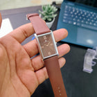 Close-up of Franklord Rustic Bronze watch with rich brown dial and silver rectangular case held in hand