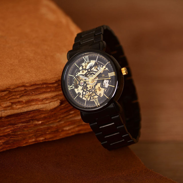 Franklord Mechanis Eclipse Noir Automatic Skeleton Watch elegantly displayed, highlighting its intricate gold skeleton dial, black stainless steel bracelet, and luxurious craftsmanship.