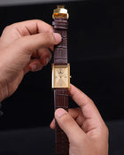 Full straight view of Franklord Royal Gold Heritage gold rectangular dial watch held in hand