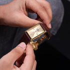 Franklord Royal Gold Heritage rectangular gold dial watch held in hand, front view
